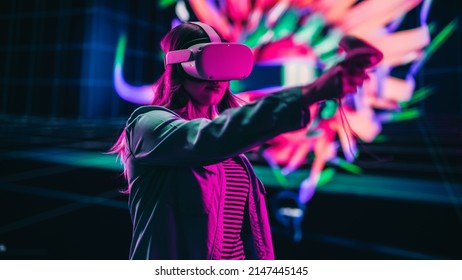 Digital Artist Using Virtual Reality 3D Software To Create A Beautiful Piece Of Art In Interactive Creative Environment. Female Designer Using Virtual Reality Headset And Controllers For NFT Project.