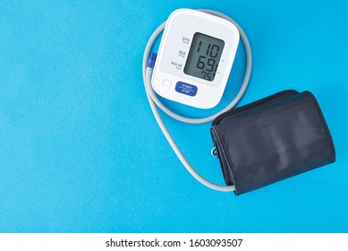 Digital Blood Pressure Monitor On Blue Background, Closeup. Helathcare And Medical Concept