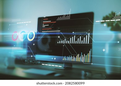 Digital business chart interface on blurry office interior background with computer monitor on desktop. Finance, trade, technology and future concept. Double exposure
