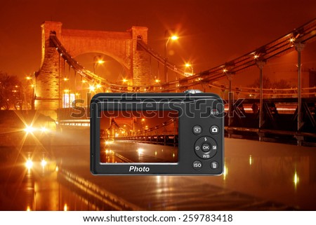 Digital camera capturing beautiful bridge illuminated by night
