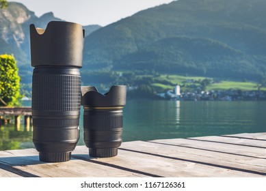 Digital camera lenses standing on wooden board with mountain landscape at background. Copy space background