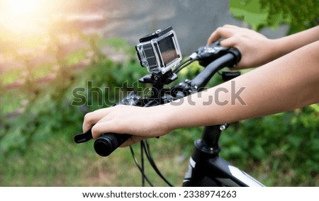 A digital camera mounted on the handlebars of a mountain bike.