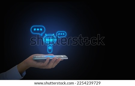 Digital chatbot, conversational agent, robot application, conversation assistant that mimic human speech. Hand holds a smartphone with digital AI chatterbot on virtual screen for online information