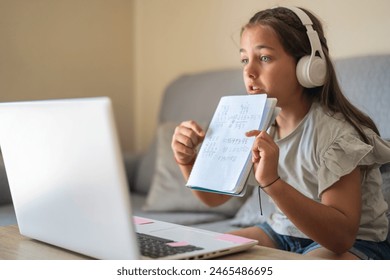 Digital Classroom: SchoolGirl Using A Computer And Webcam To Join An Online Class At Home. Student Interacting With Peers And Teacher Through A Virtual Platform To Discuss Homework. - Powered by Shutterstock