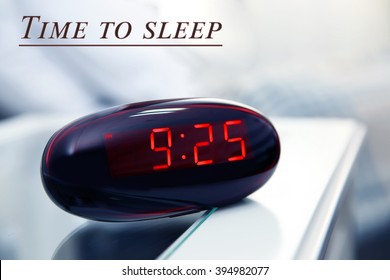 Digital clock showing 9:25 o'clock on a bedside table in bedroom - Powered by Shutterstock