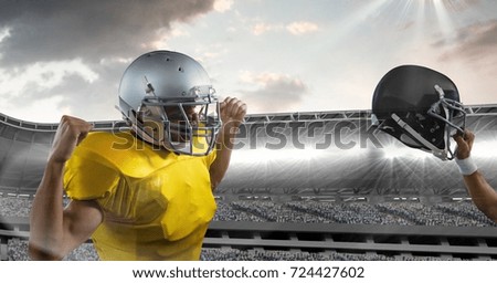 Digital composite of american football player cheering and holding up helmet