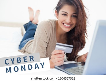 Digital composite of Cyber Monday Sale Woman lying in front of laptop with creditcard in her hand - Powered by Shutterstock