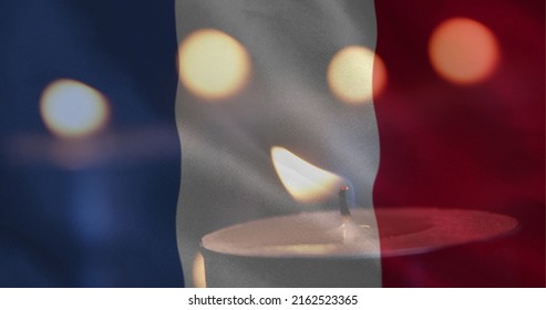 Digital composite of French flag with candles in the background. One candle going out 