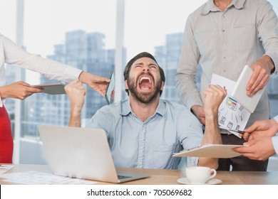 Digital Composite Of Frustrated Business Man At A Desk Yelling