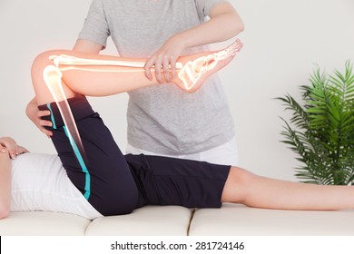 Digital composite of Highlighted bones of woman at physiotherapist - Powered by Shutterstock