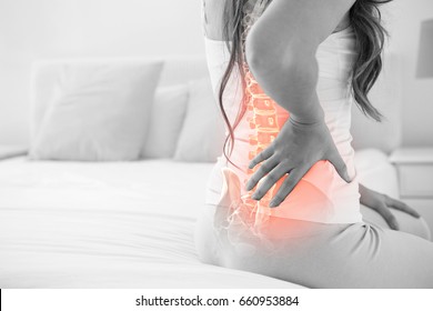 Digital Composite Of Highlighted Spine Of Woman With Back Pain At Home