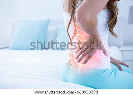 Digital composite of highlighted spine of woman with back pain at home
