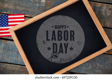 Digital composite image of happy labor day text poster against overhead view of chalkboard with american flag - Shutterstock ID 697239130