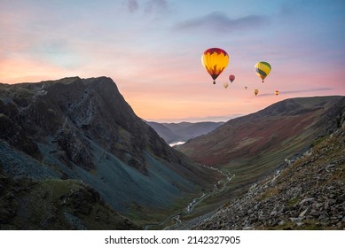 Digital composite image of hot air balloons over Epic landscape image of view down Honister Pass to Buttermere from Dale Head in Lake District during Autumn sunset