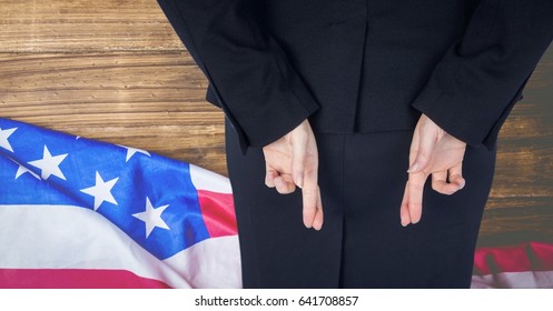 Digital composite of Rear view of businesswoman with fingers crossed against American flag - Powered by Shutterstock