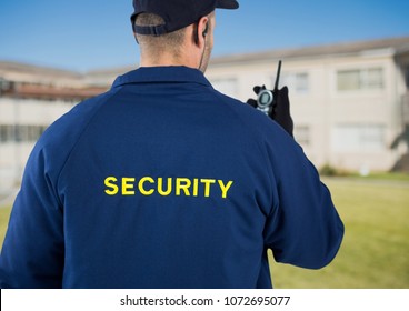 Digital Composite Of Rear View Of Security Guard Using Radio Against House