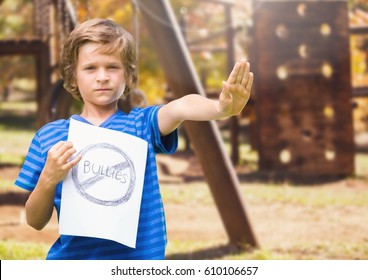 Digital Composite Of Sad Boy Holdingn Anti Bullying Sign Against Playground