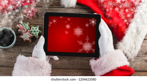 Digital composite of Santa holding tablet with snowflakes - Powered by Shutterstock