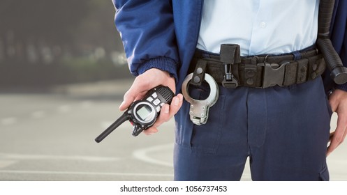 Digital composite of Security guard lower body with walkie talkie against blurry street - Powered by Shutterstock