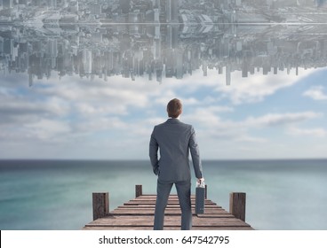 Digital composite of up side down city in the sky over the sea with dock. Men looking up. - Powered by Shutterstock