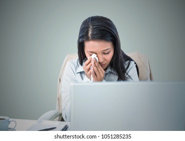 Digital Composite Of Woman Crying At Computer Against Light Blue Background