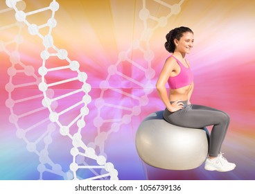 Digital Composite Of Woman Doing Exercise With A Ball And Dna Chain And Colors Background