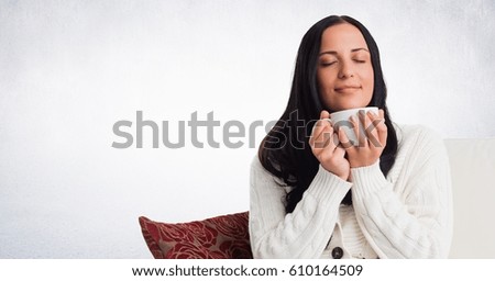 Digital composite of Woman on couch with white mug against white wall