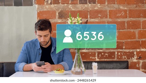 Digital composite of young Caucasian man using mobile while sitting at table with pastry and message bubble with follower icon and number count up in the foreground. - Powered by Shutterstock