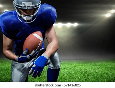 Digital composition of american football player holding rugby ball against stadium in background - Powered by Shutterstock