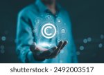 Digital copyright, patent concept. Businessman hold digital icons representing copyright, intellectual property, patents, legal protection, and safeguarding digital and intellectual assets. trademark,