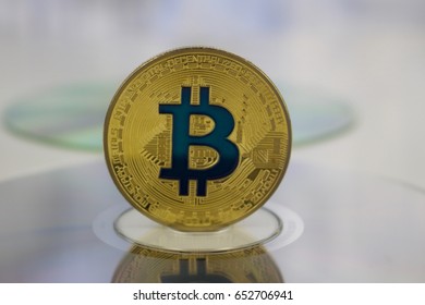 Digital currency physical gold bitcoin coin on CD. Financial concept.