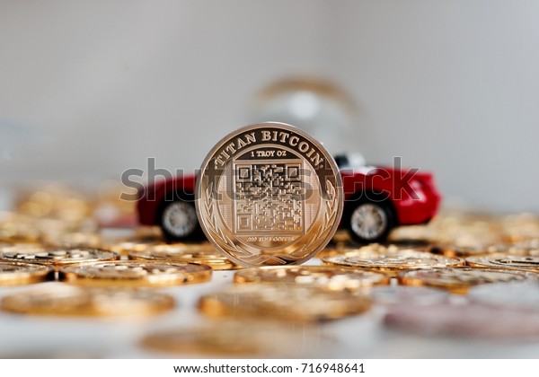 Digital currency physical metal\
bitcoin coin near red luxury car. Finance cryptocurrency\
concept.
