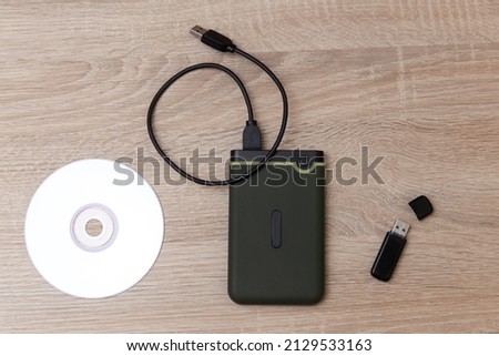 Digital custodians of information. External hard drive, cd and usb flash drive on a wooden table