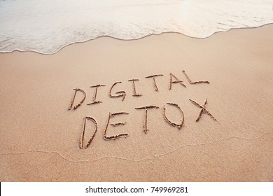 digital detox concept, words written on the sand of beach