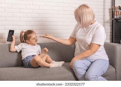 Digital detox. Mother taking smartphone from her little child. Children's gadget dependence, technology internet addiction. Parental control, upbringing concept. - Powered by Shutterstock