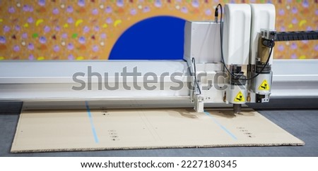 Digital die cut machine cutting corrugated cardboard. Industrial manufacture.