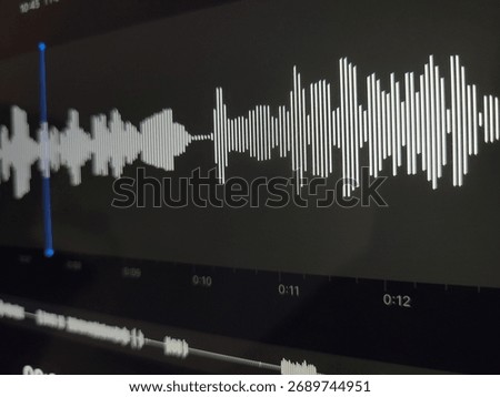 A digital display of an audio waveform with a cursor on a dark background.
