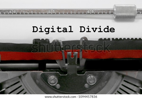 Digital divide text written by an old typewriter on\
white sheet