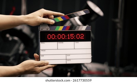 Digital film slate for filmmaker in set. Hand hitting timecode clapperboard or movie slate for Video Production. Digi number clapper board or film slates action on set. Tools in modern cinema industry