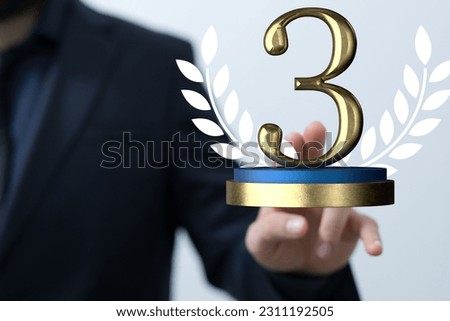 A digital floating 3rd place golden prize celebration logotype with a businessman's hand touching it