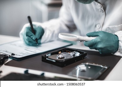 Digital Forensic Science. Police Forensic Analyst Examining Computer Hard Drive.