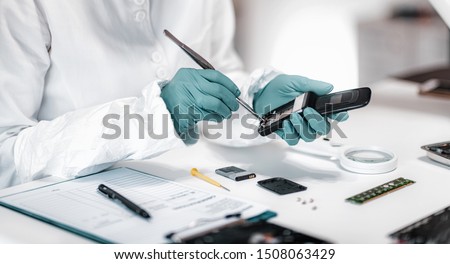 Digital Forensic Science. Police Forensic Analyst Examining Confiscated Mobile Phone.