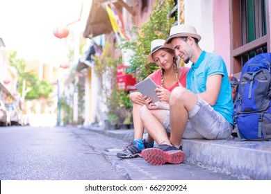 Digital guide. Tourism and technology. Traveling couple of backpackers using digital tablet outdoor. - Powered by Shutterstock