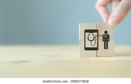 Digital healthcare and futuristic medical technology concept. Hand holding wooden cubes with symbols of  M-health, mobile healthcare, online medical, medical service, online doctor. Grey background. - Shutterstock ID 2083372828