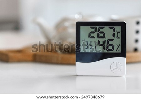Digital hygrometer on table in kitchen, closeup