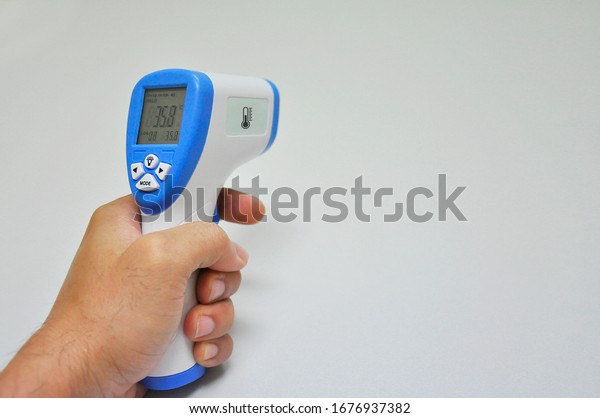 Digital Infrared Thermometer\
(thermometer gun) for check forehead temperature measurement\
screening from Coronavirus Disease 2019 (COVID-19). White\
background
