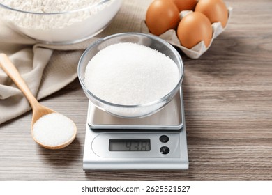 Цифровые кухонные весы с чашей сахара и ложкой на деревянном столе, закрывается