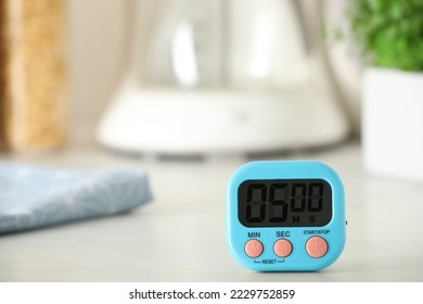 Digital kitchen timer on white table indoors. Space for text