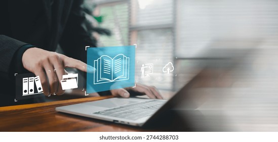 Digital knowledge management and online documentation concept with virtual book icon over laptop. E learning, cloud storage, data archive, information access and business training technology.