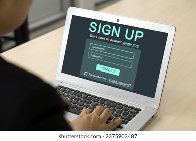 Digital Life Exploration. A focused businessman in black suit engrossed in creating his identity online, registering for an account on his laptop computer. - Powered by Shutterstock